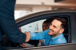 Young couple shaking hands after a successful car buying
